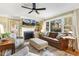 Bright living room with fireplace, large windows, ceiling fan, and hardwood floors at 105 Blanchard St, Fuquay Varina, NC 27526