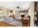 Cozy living room features a fireplace, ceiling fan, large windows, and hardwood floors at 105 Blanchard St, Fuquay Varina, NC 27526