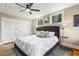Bright bedroom featuring a large bed, two windows, a ceiling fan, and plenty of closet space at 105 Blanchard St, Fuquay Varina, NC 27526