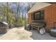 Outdoor patio with grill, overlooking lush green landscaping and a wooded backdrop at 105 Blanchard St, Fuquay Varina, NC 27526