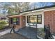 Inviting brick and white trimmed porch featuring dark framed windows and bench at 105 Blanchard St, Fuquay Varina, NC 27526