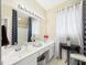 Bright bathroom with double vanity, modern lighting, and decorative accents, plus blue patterned shower curtain at 10836 Connally Ln, Raleigh, NC 27614