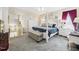 Large primary bedroom has a sitting area, four-poster bed, ceiling fan, and neutral color scheme at 10836 Connally Ln, Raleigh, NC 27614