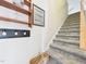 Stairwell with carpeted steps, hand rail, coat rack, wall decorations, and a decorative basket at 10836 Connally Ln, Raleigh, NC 27614
