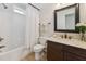 Bathroom features a shower-tub combo, vanity with dark wood cabinets and framed mirror at 11003 Louson Pl, Raleigh, NC 27614