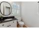 Powder room with oval mirror and granite counters at 11003 Louson Pl, Raleigh, NC 27614