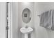 A small bathroom with a pedestal sink, oval mirror, and a towel rack at 1107 Pale Moss Dr, Durham, NC 27704