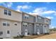 Townhome exteriors showcase neutral colors, complemented by a well-maintained lawn and inviting back doors at 1107 Pale Moss Dr, Durham, NC 27704