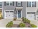 Up close view of a townhome featuring a one-car garage, blue door, and tidy front yard at 1107 Pale Moss Dr, Durham, NC 27704