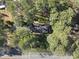 Aerial perspective of a well-maintained ranch home, surrounded by mature trees and lush landscaping at 11801 Strickland Rd, Raleigh, NC 27613