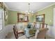 Elegant dining room with a glass table, chandelier, and decorative mirror and painting at 11801 Strickland Rd, Raleigh, NC 27613