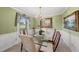 Elegant dining room with a glass table, chandelier, and decorative mirror and painting at 11801 Strickland Rd, Raleigh, NC 27613
