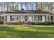 Charming ranch-style home with brick and siding exterior, red front door, and manicured landscaping at 11801 Strickland Rd, Raleigh, NC 27613