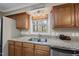 Kitchen with wood cabinets, granite counters, and a stainless steel dishwasher, for easy meal preparation at 11801 Strickland Rd, Raleigh, NC 27613