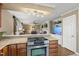 An open kitchen with stainless steel oven and cooktop looks into a living room with fireplace and television at 11801 Strickland Rd, Raleigh, NC 27613