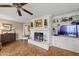 Living room with a white brick fireplace, built-in shelving, and hardwood floors at 11801 Strickland Rd, Raleigh, NC 27613