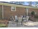 Backyard patio with brick exterior, a table and chairs, and nearby door and stairs at 11801 Strickland Rd, Raleigh, NC 27613
