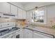 Bright kitchen featuring white cabinets, granite countertops, and a window view at 1248 Jamestown Ct, Cary, NC 27511