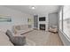 Cozy living room with a fireplace, plush seating, and natural light from the window at 1408 Weavers Trace Dr, Zebulon, NC 27597