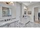 Bright bathroom featuring granite countertops, framed mirrors, and tile flooring leading to an expansive walk-in closet at 147 Glenpark Pl, Cary, NC 27511