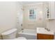 Bright bathroom featuring tiled walls, a window, and a bathtub with shower at 164 Torain St, Hillsborough, NC 27278