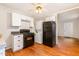 Cozy kitchen features white cabinetry, black appliances, and hardwood floors at 164 Torain St, Hillsborough, NC 27278