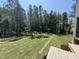 Backyard view from deck featuring a lush lawn and a view of the surrounding trees and neighboring home at 170 Cherry Bark Dr, Youngsville, NC 27596