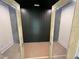 A view through open doors reveals a room with a dark accent wall and painted concrete floors in the basement at 170 Cherry Bark Dr, Youngsville, NC 27596