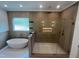 Luxurious bathroom with a soaking tub and walk-in shower with a stone floor at 170 Cherry Bark Dr, Youngsville, NC 27596