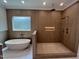 Modern bathroom featuring a bathtub, shower, and stone floors at 170 Cherry Bark Dr, Youngsville, NC 27596