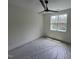 Bedroom with a sleek ceiling fan and a window looking out to trees, while covered in protective plastic sheeting at 170 Cherry Bark Dr, Youngsville, NC 27596