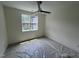 Bedroom with a modern ceiling fan and large window bringing in natural light, covered in protective plastic sheeting at 170 Cherry Bark Dr, Youngsville, NC 27596
