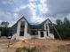 Two-story home with white brick, gray siding and a black roof against a cloudy sky at 170 Cherry Bark Dr, Youngsville, NC 27596