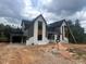 Two-story home with white brick, gray siding and black roof featuring an attached garage at 170 Cherry Bark Dr, Youngsville, NC 27596