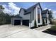 Modern home featuring a three-car garage, landscaped yard, and stylish exterior at 170 Cherry Bark Dr, Youngsville, NC 27596