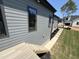 Exterior view showcases the home's gray siding, dark trim windows and door frames, and a backyard deck at 170 Cherry Bark Dr, Youngsville, NC 27596