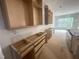 Unfinished kitchen with wood cabinets and a large window to the backyard at 170 Cherry Bark Dr, Youngsville, NC 27596