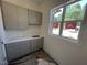 Laundry room features gray cabinets, white countertop and a bright window with a view of the outside at 170 Cherry Bark Dr, Youngsville, NC 27596