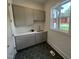 This laundry room boasts ample counter space, sleek cabinets, and stylish hexagon flooring at 170 Cherry Bark Dr, Youngsville, NC 27596