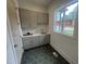 Laundry room with stylish cabinets, sink, and modern hexagon tile floor, offering practicality and charm at 170 Cherry Bark Dr, Youngsville, NC 27596
