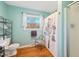 Bathroom with wood floors, toilet, sink, shower, and window letting in natural light at 1805 Lawrence Rd, Hillsborough, NC 27278