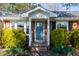 Charming brick home featuring a welcoming blue front door and well-manicured landscaping at 1805 Lawrence Rd, Hillsborough, NC 27278