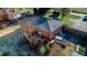 Aerial view of a brick home with a dark roof, wooden deck, and landscaped backyard at 1805 Lawrence Rd, Hillsborough, NC 27278