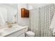 This bathroom includes a shower with patterned curtain, a vanity, a toilet, and a wall cabinet for ample storage at 190 Salem Village Dr, Fuquay Varina, NC 27526