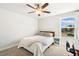 This bedroom features a ceiling fan, a cozy bed, and a bright window offering views of the outdoors at 190 Salem Village Dr, Fuquay Varina, NC 27526