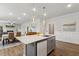 Bright kitchen with gray cabinets, quartz countertops, a central island, and an open layout to the dining area at 190 Salem Village Dr, Fuquay Varina, NC 27526