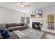 Relaxing living room with a cozy fireplace, large sofa, and scenic views from the window at 190 Salem Village Dr, Fuquay Varina, NC 27526