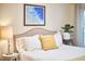 Comfortable bedroom with a linen headboard, yellow pillow, and a plant at 1921 Clark Ave # 105, Raleigh, NC 27605