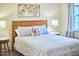 Close up of a well appointed bedroom, showing a wooden headboard, throw pillows, and natural light at 1921 Clark Ave # 105, Raleigh, NC 27605