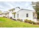 A white exterior home, with a lush green lawn and various plants surrounding the foundation at 1921 Clark Ave # 105, Raleigh, NC 27605